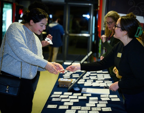 An attendee is handed their nametag at the 2024 Donor/Scholar Reception