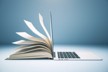 A book with fanned pages seamlessly merging into a laptop screen.