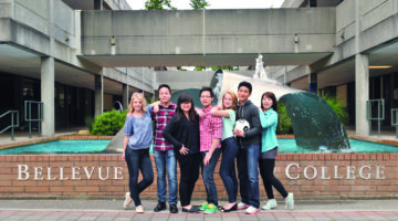 Group of students standing together in front of the Bellevue College campus fountain.