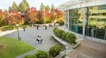 Aerial view of Bellevue College campus with students walking along a pathway near academic buildings.