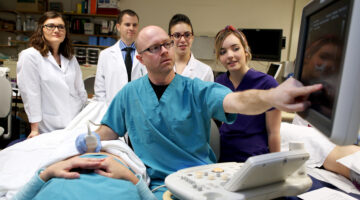 Instructor demonstrating medical equipment to students in a hands-on learning environment.