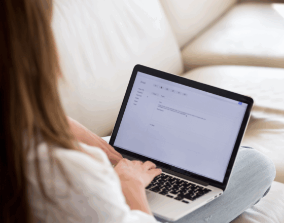Women sitting on a couch and working on their computer