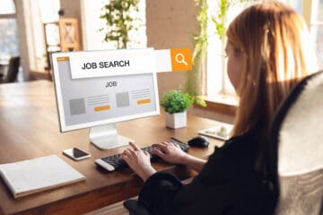 Women sitting on at a desk and searching for a job on her computer