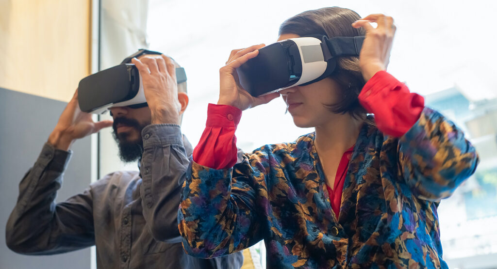 Two people use VR headsets.