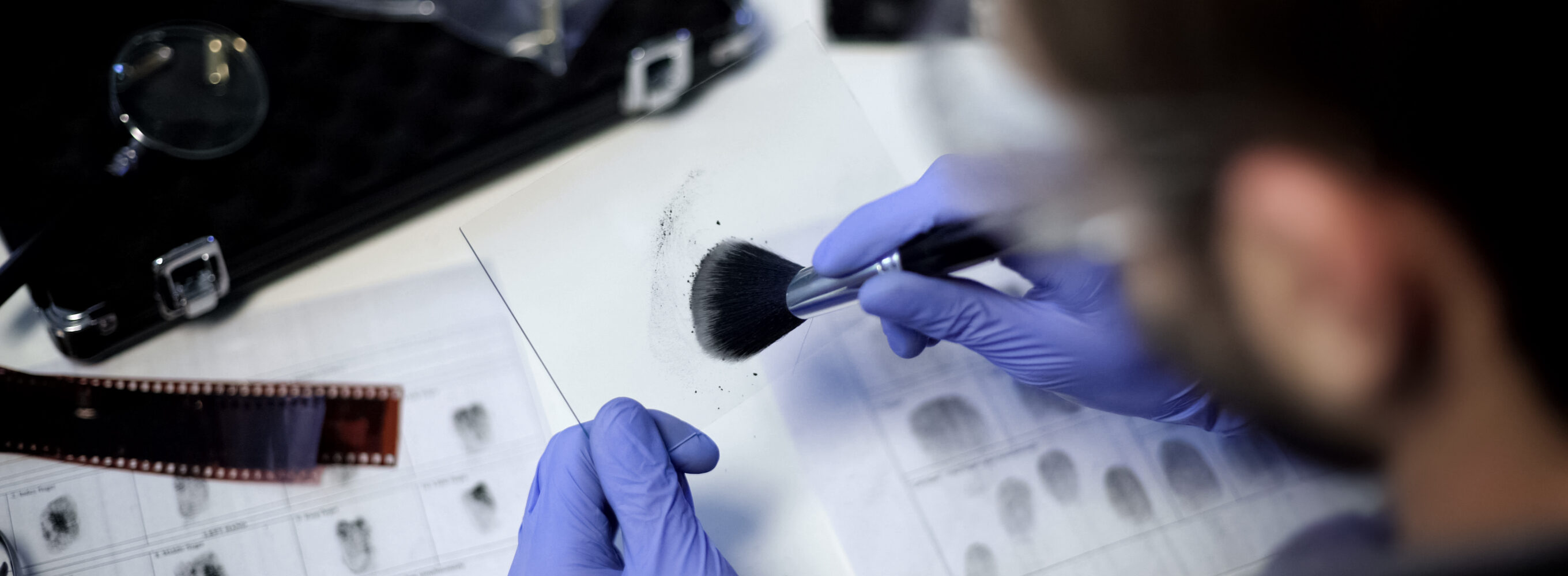 Forensic worker dusting glass for fingerprints