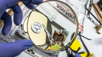 Police examining hard drive with magnifying glass