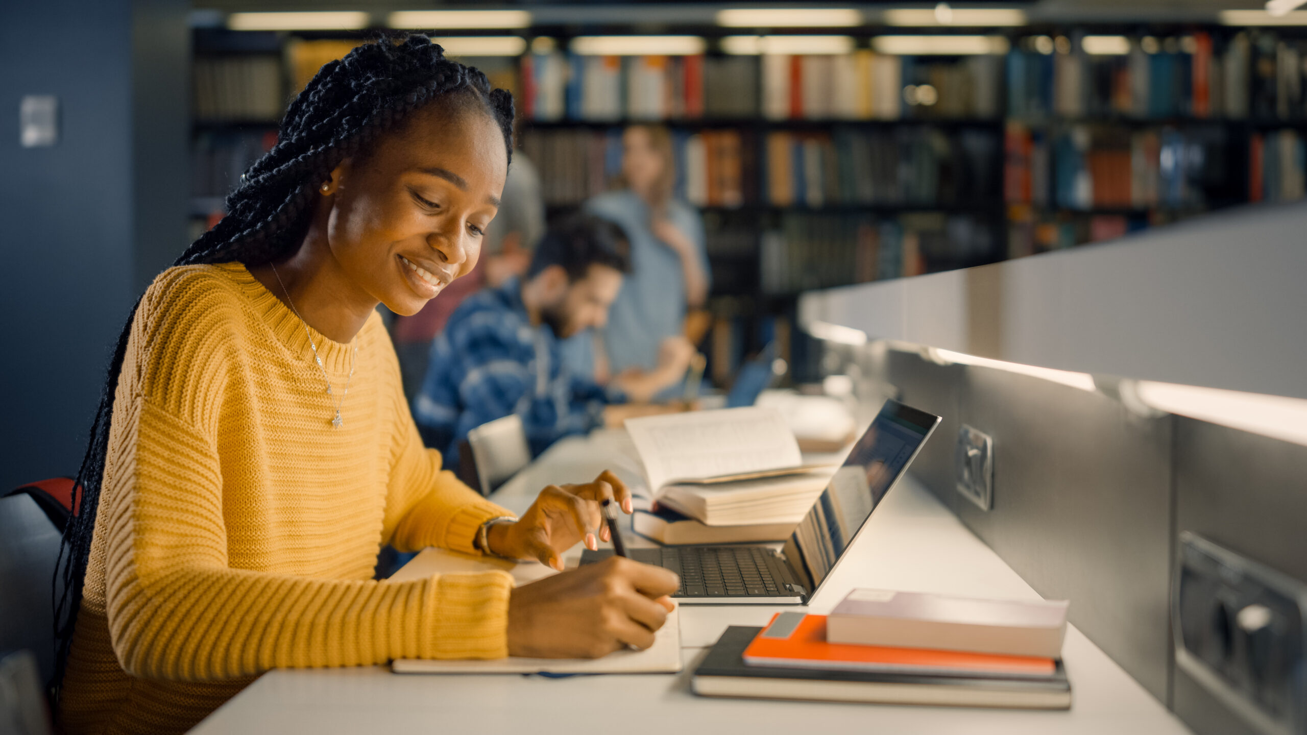 Student typing on laptop in library