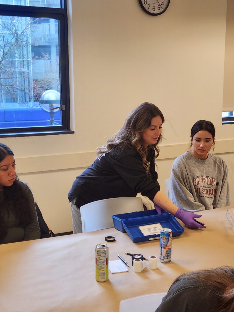 Fingerprint analyst demonstrating techniques to two students