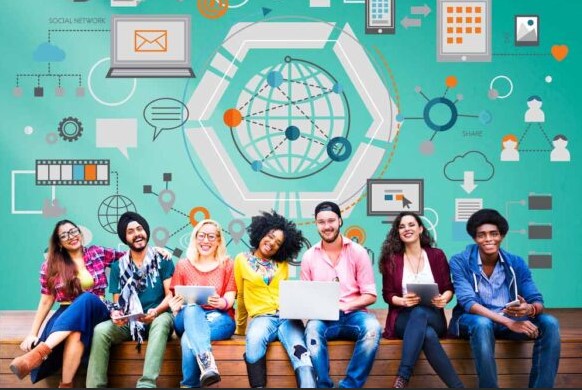 Diverse students sitting together smiling with tech gadgets and tech graphics behind them
