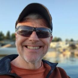 profile headshot of Ron Austin outside smiling and wearing sunglasses