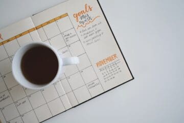cup of coffee sitting on a calendar book