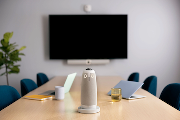 Owl meeting setup with conference table, six chairs, and a digital screen on the wall