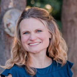 headshot of Amilee Roberge smiling outside with trees and sunlight in the background