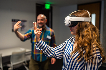 A student learns how to use the VR headset and technology.