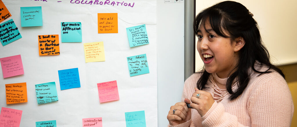 An OLS student makes a presentation in front of a whiteboard.