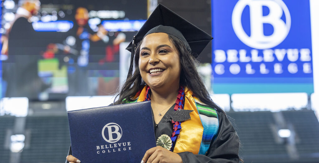 A new BC alum celebrates with their diploma.