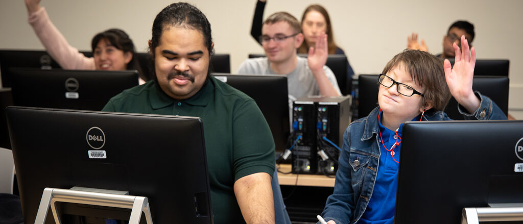 Occupational & Life Skills students raise their hands in class.