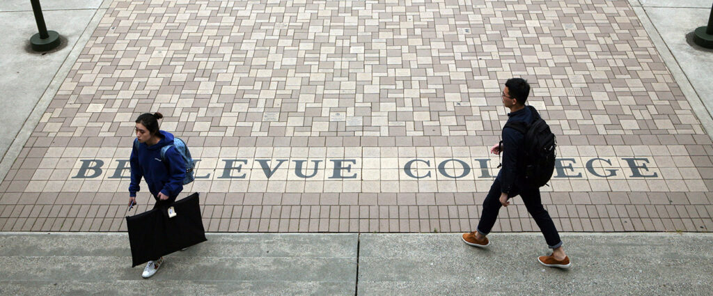 Students stroll over courtyard tiles that say "Bellevue College."