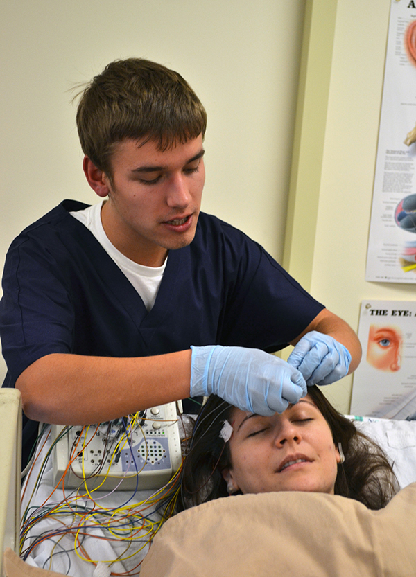 A student simulates a medical procedure in class.