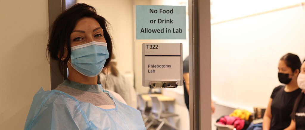 Students are shown in and around the Phlebotomy lab.