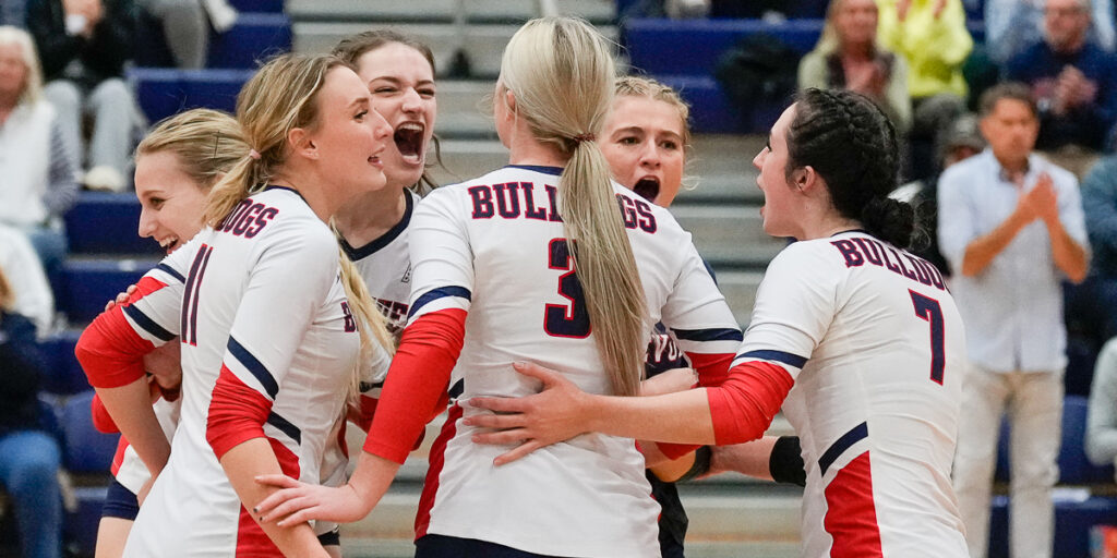 Bulldog volleyball players rally during a huddle.