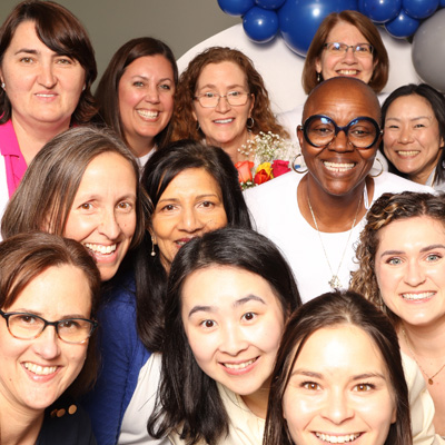 Group of people celebrating gather together and pose with big smiles