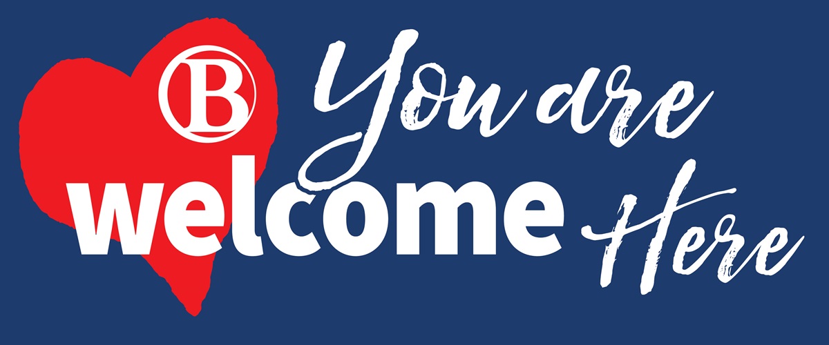 BC You are welcome here sign on blue background with red heart.