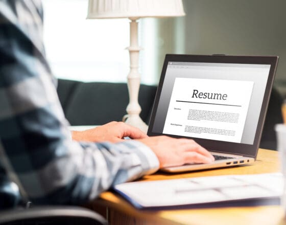 Man editing their resume on a computer while sitting in a desk