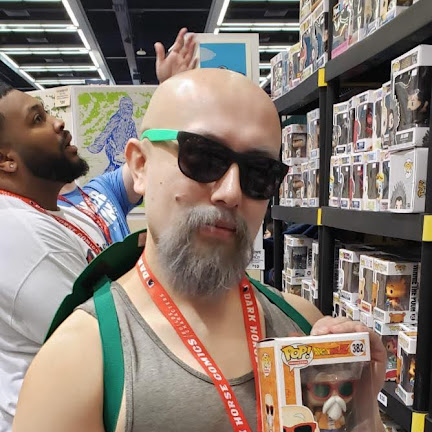 Man holding a boxed collectible figure in a store aisle.