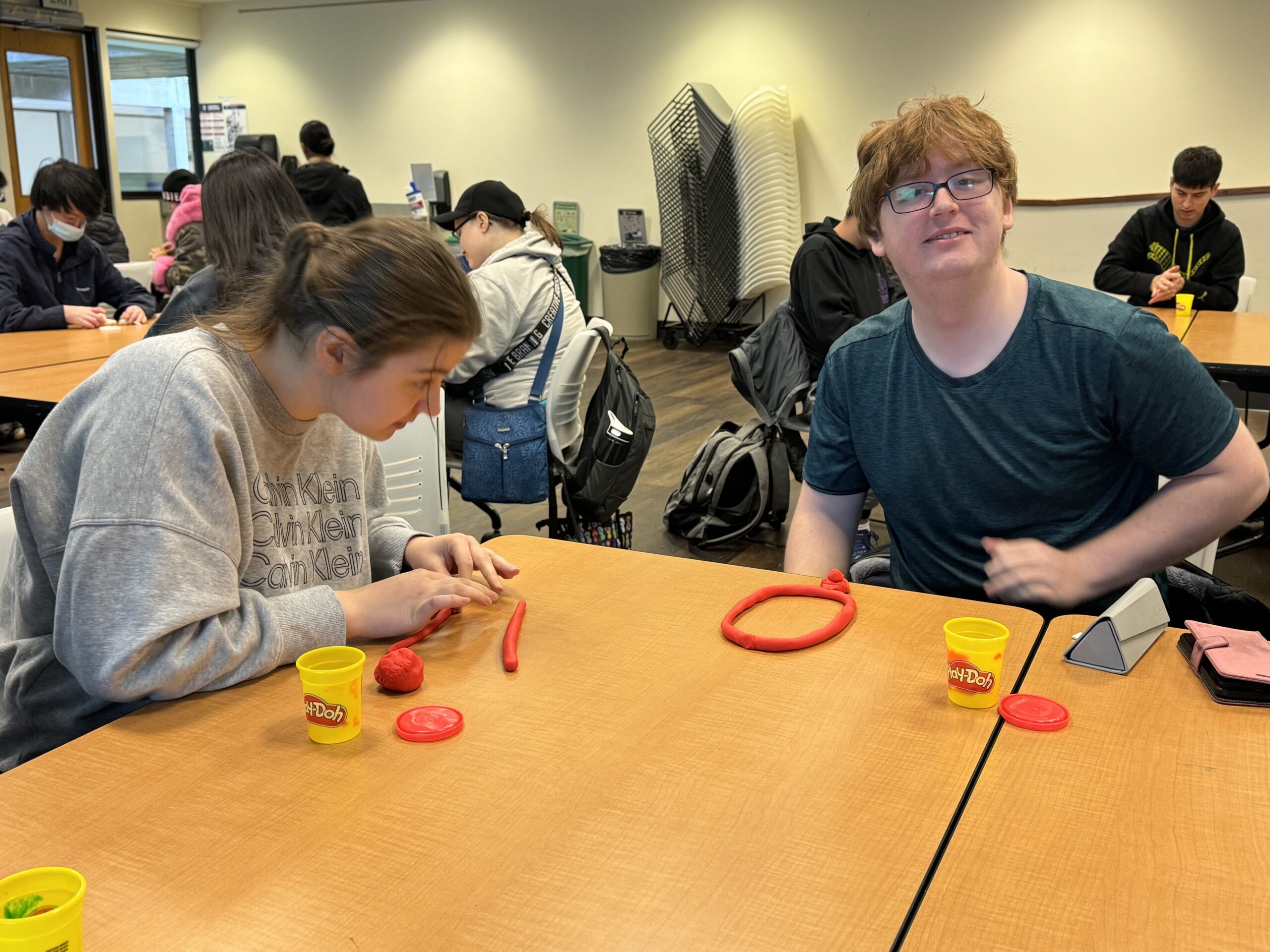 OLS students participate in a play doh experiment for intro to communications course