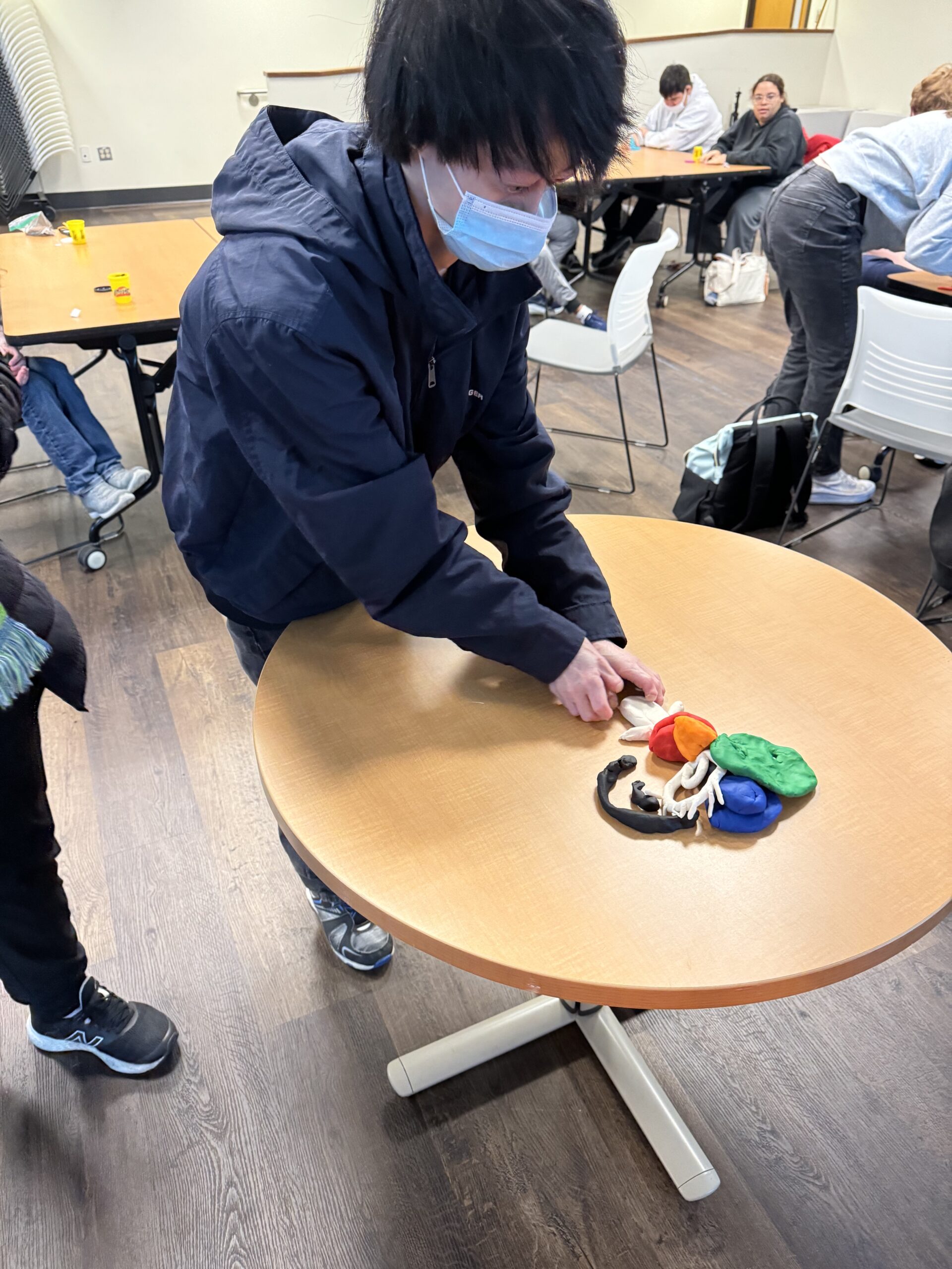 OLS students participate in a play doh experiment for intro to communications course