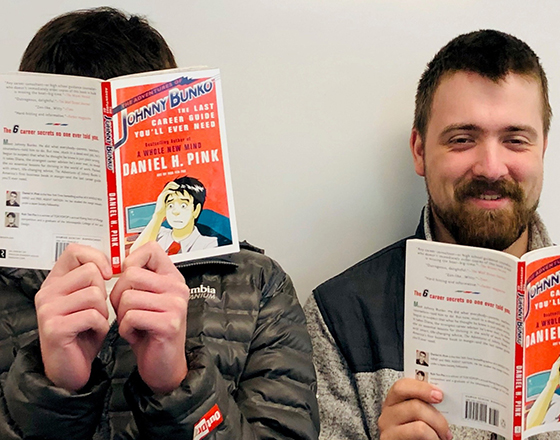 OLS students playfully read books on career advice.