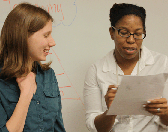 Instructors consult paperwork together.