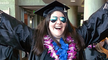 A proud OLSBC alum celebrates at graduation.