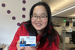 An OLS intern proudly shows off her employee badge.