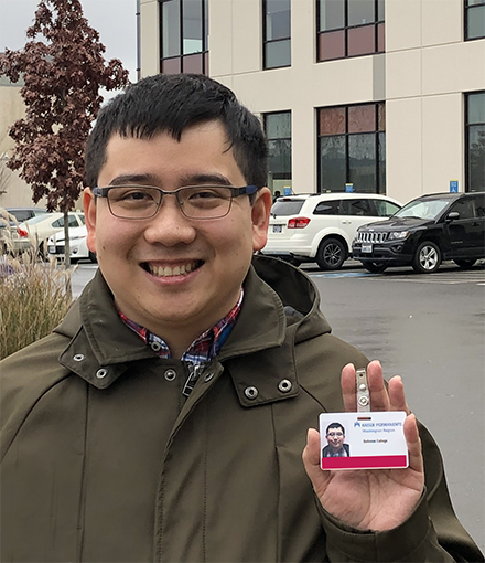 An OLS intern displays his employee badge.