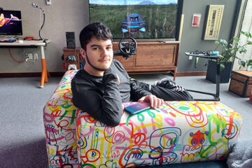 An OLS student relaxes on a couch.