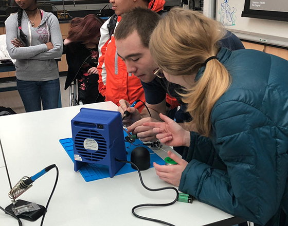 OLS students and faculty work on a demonstration of a motor.