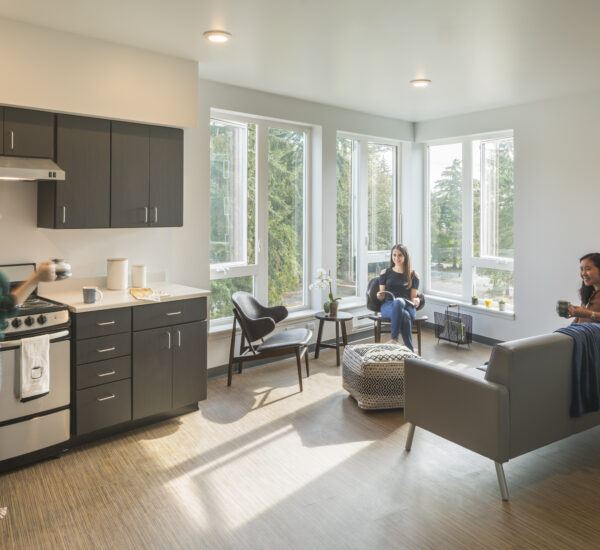 Students enjoy food in a kitchen area of BC housing.