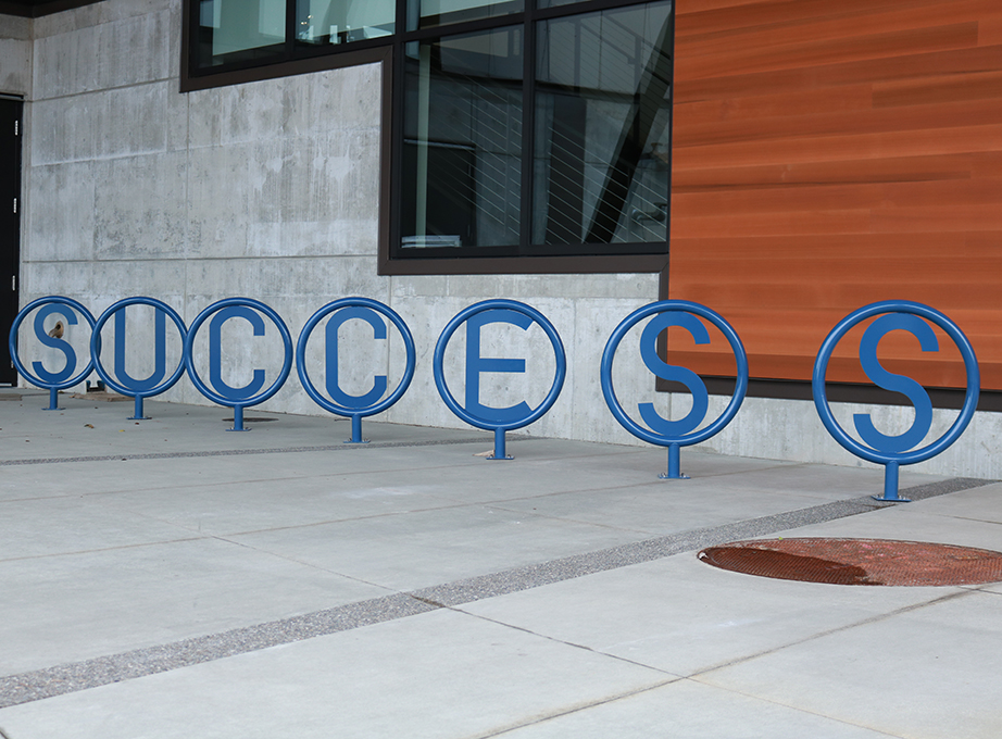 The bicycle rack in front of the U Building spells out "Success."