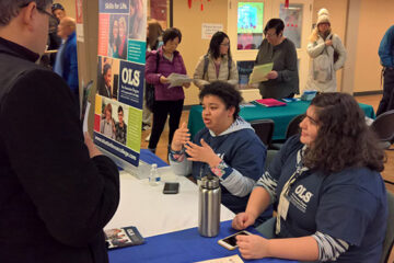 OLS students staff an information table and interact with visitors.