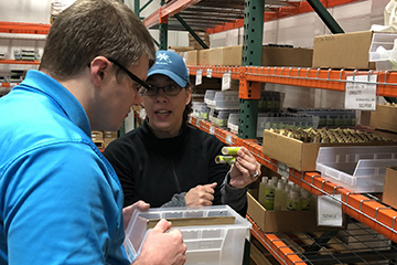 AN OLS student receives instruction about products in a warehouse.