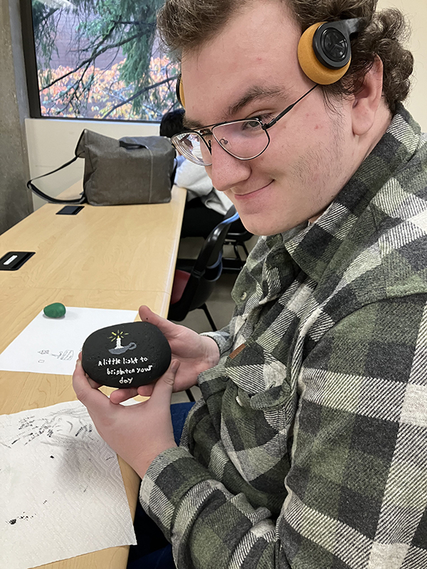 An OLS student paints kindness rocks.