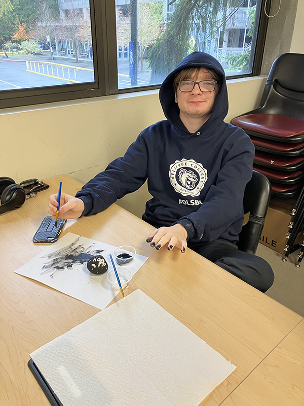 An OLS student paints kindness rocks.