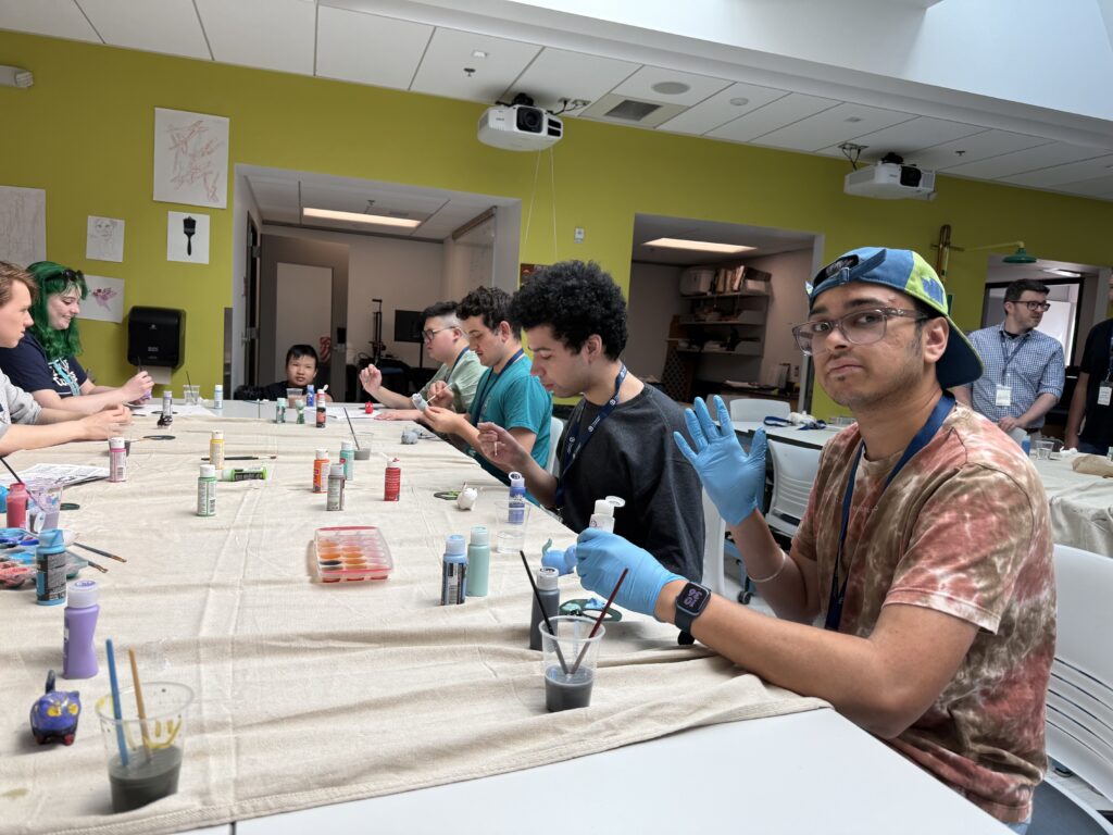 Summer campers paint ceramic figures 
