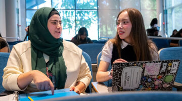 Two female students talking to each other on campus
