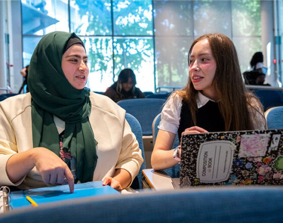 Two female students talking to each other on campus