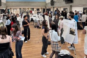 Bellevue College students are looking at each other's posters and projects.