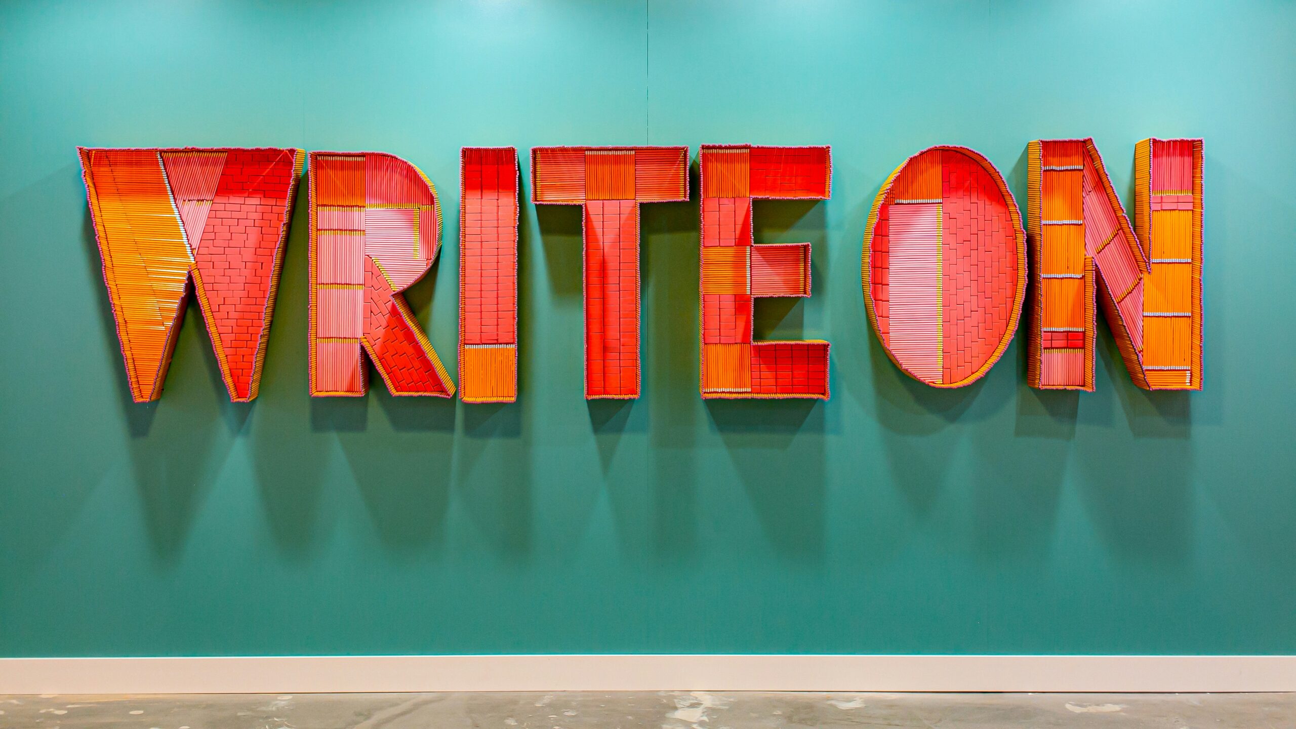 Art made out of hundreds of pencils spelling "WRITE ON"