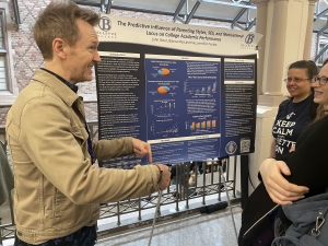 John Stout explains the data to Dr. Stacy Alvares and a UW psych student at the UW Undergraduate Research Symposium, 2026.